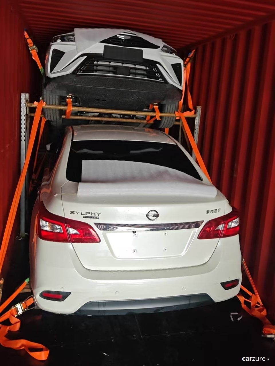 Two vehicles braced and strapped inside a shipping container